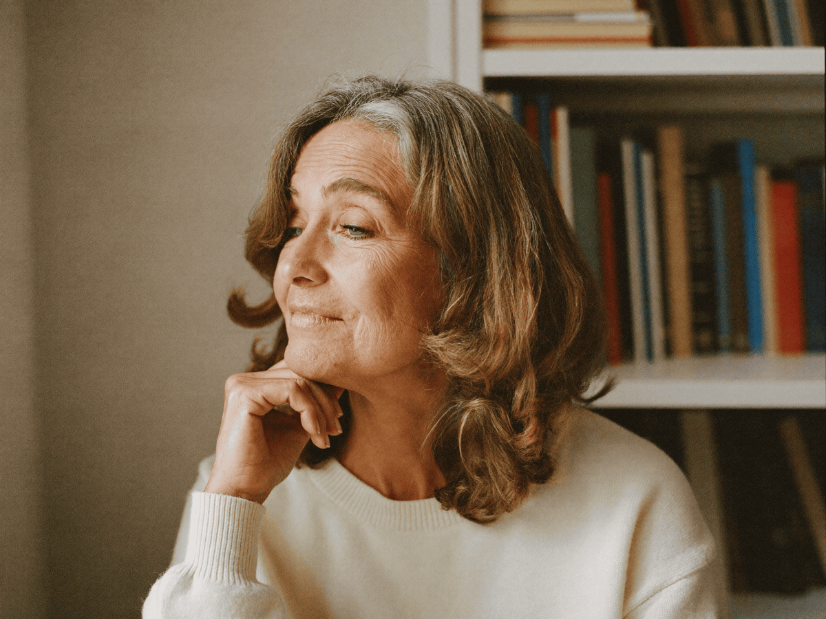 Marion, 51 ans, pensive à la fenêtre de son appartement parisien